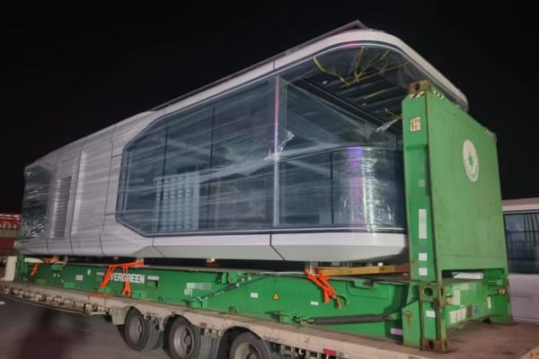 Space capsule house being transported on a flatbed truck, showcasing modular design and easy relocation for modern housing